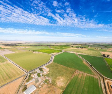 Drone shot of a green fields and clear skies